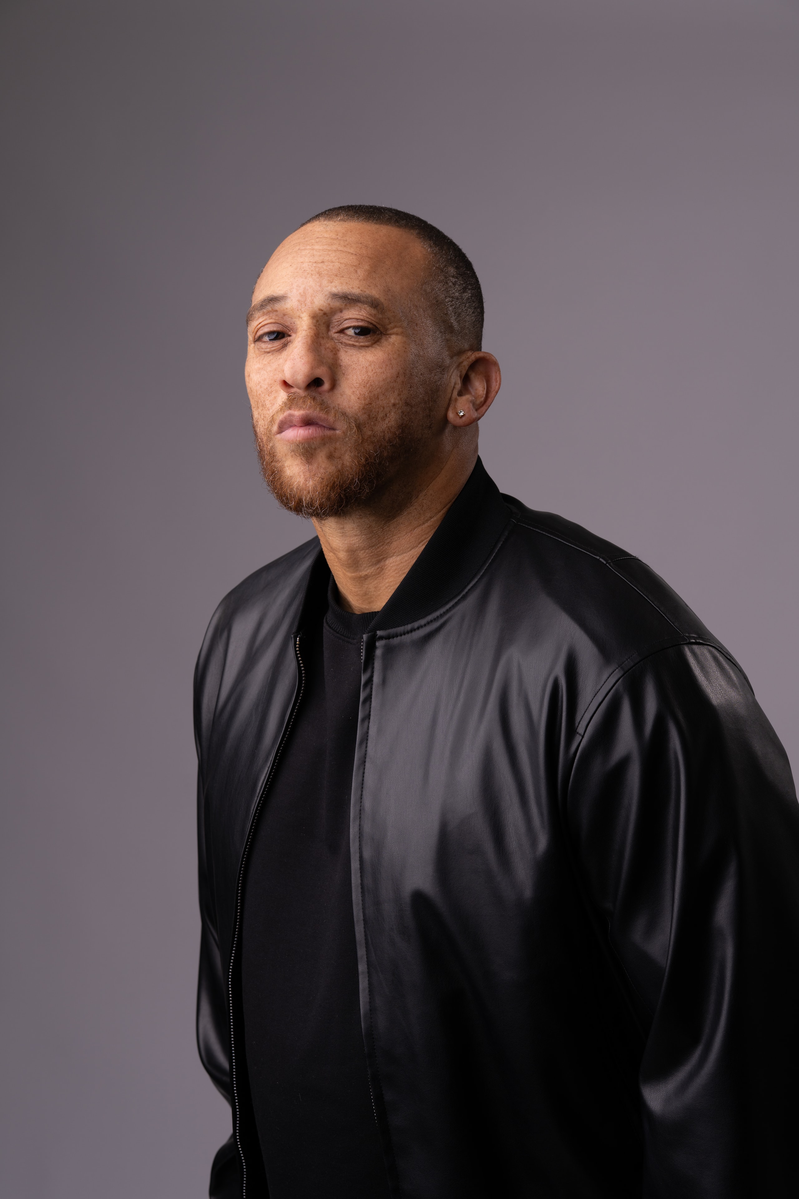 Kev Choice in black leather bomber jacket studio portrait