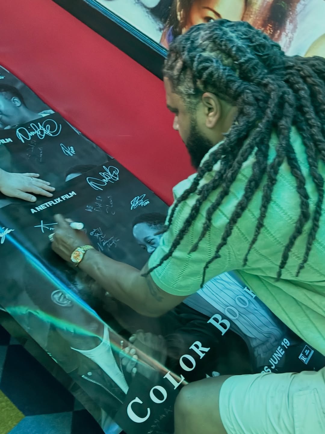 Kia Shine signing the Color Book Netflix poster